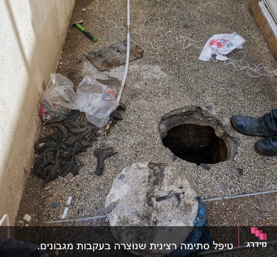 בור פתוח ברצפה עם כלי עבודה ופסולת
